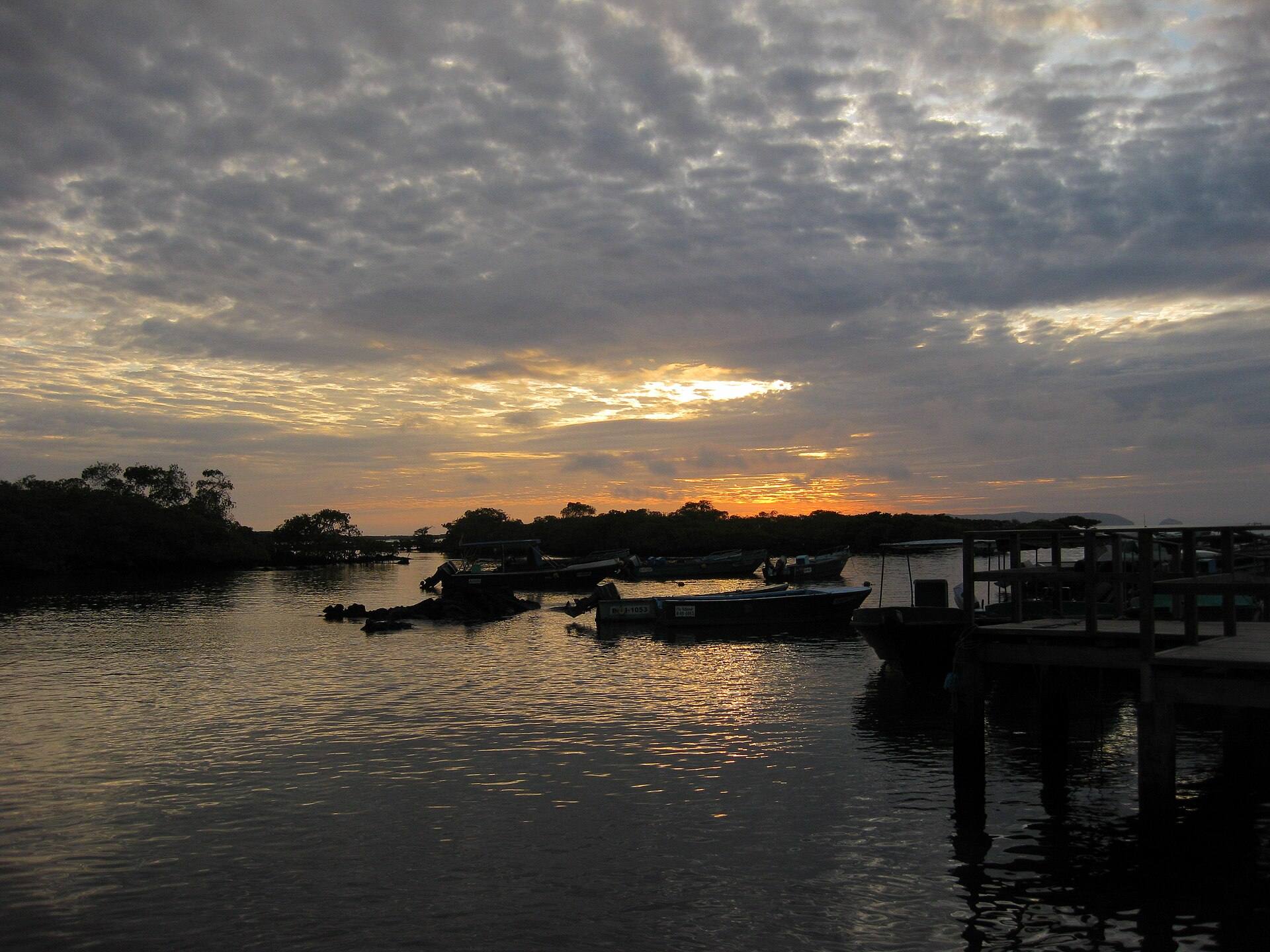 Small boats and the Puerto Villamil landing area at sunset